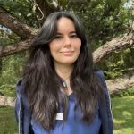 Sam - female with long dark hair wearing a blue shirt